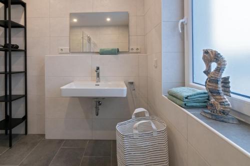 uma casa de banho com um lavatório e um espelho em Seeperle em Dornum