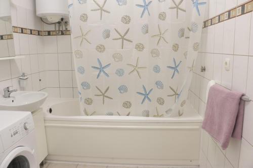 a bathroom with a shower curtain with blue starfish at Beachfront Sunshine apartment in Split