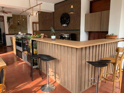 una cocina con encimera de madera con taburetes negros en Hotel el regidor, en Buga