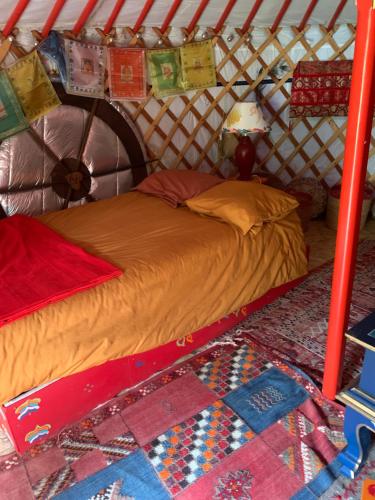 a bed in a yurt with a quilt on it at la yourte du moulin in Champrond