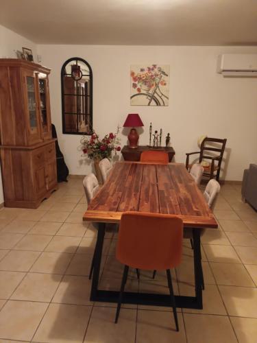 une salle à manger avec une table et des chaises en bois dans l'établissement Maison de famille, à Saint-Julien-de-Cassagnas
