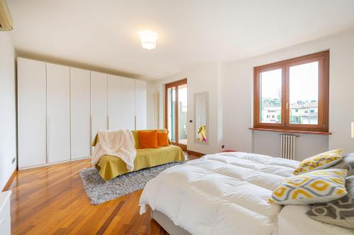 a white bedroom with a bed and a chair at Villa Calmasino - Swimming Pool and Garda Lake in Cavaion Veronese