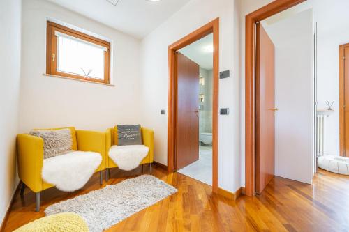 a living room with a yellow couch and a mirror at Villa Calmasino - Swimming Pool and Garda Lake in Cavaion Veronese