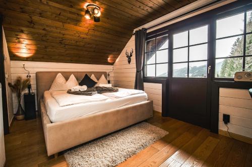 een slaapkamer met een bed in een kamer met een raam bij MountainView Lodge - Am Fuße der Gondel und Skipiste in Sankt Oswald