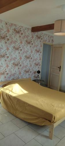 a bed in a room with a flowery wall at Les garrigues 1er étage in Pernes-les-Fontaines