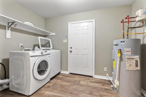 a laundry room with a washing machine and a refrigerator at Renovated Home Perfect for Family in Mobile