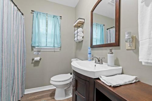 y baño con lavabo, aseo y espejo. en Renovated Home Perfect for Family en Mobile