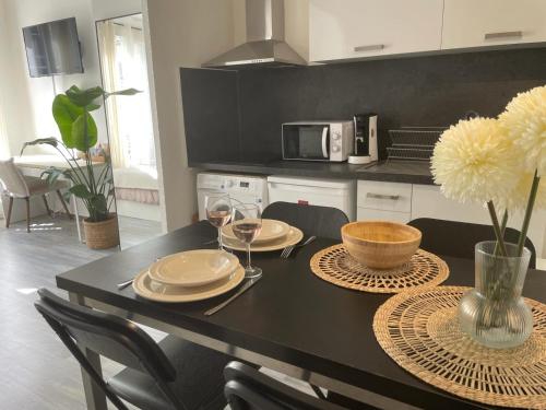 une cuisine avec une table avec des assiettes et des verres à vin dans l'établissement Studio Aix Centre Historique, à Aix-en-Provence