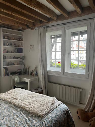 une chambre avec un lit et deux fenêtres dans l'établissement Deux chambres en plein cœur de Montmartre, Paris, à Paris