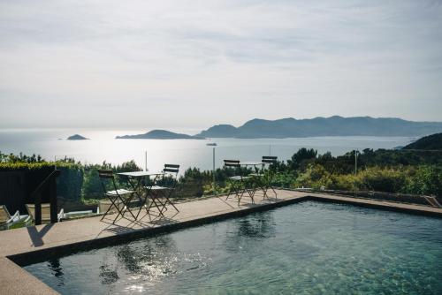a swimming pool with chairs and a table and the water at Golfo dei Poeti Relais & Spa in Ameglia