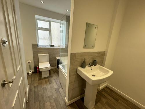 Baño blanco con lavabo y aseo en Scotch Terrace - 3 Bed House, en Whitehaven