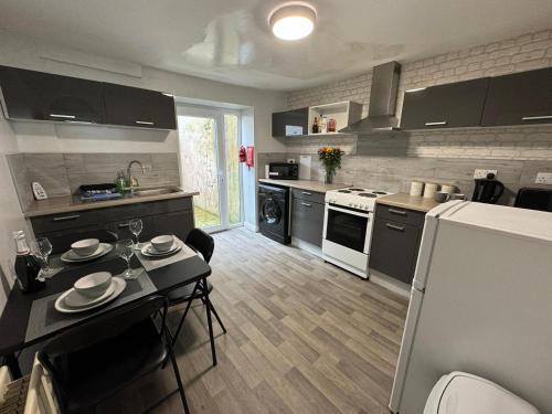 a kitchen with a table and a kitchen with a refrigerator at Scotch Terrace - 3 Bed House in Whitehaven