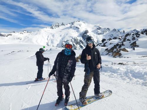 3 personnes à skis dans la neige sur une montagne dans l'établissement Cabaña Los Lúpulos, à El Bolsón