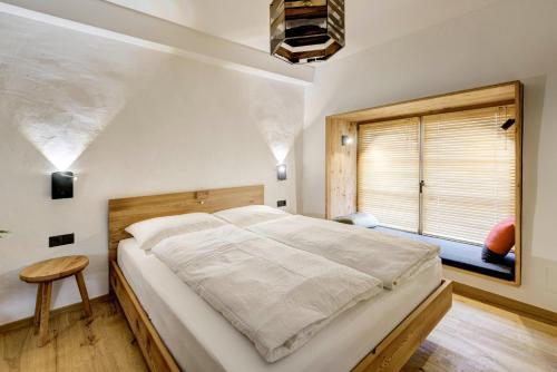 a bedroom with a large bed and a window at Labe Biohof Oberzonn in Kastelruth