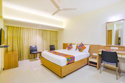 a hotel room with a bed and a desk and a bed sidx sidx at FabExpress Kuber in Navi Mumbai