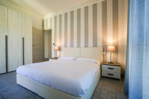 um quarto com uma grande cama branca e 2 candeeiros em Montalto House em Turim