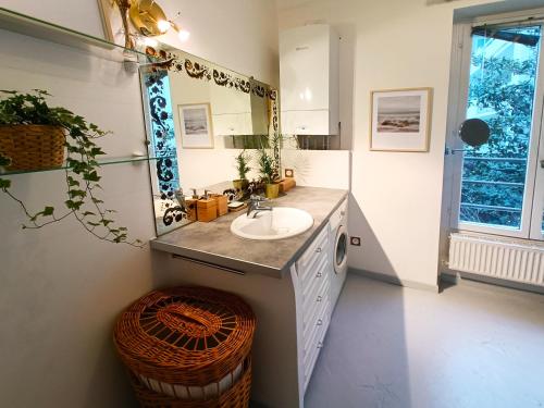 La salle de bains est pourvue d'un lavabo et d'un miroir. dans l'établissement Peaceful apartment with private garden, à Clichy