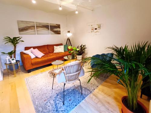- un salon avec un canapé et des plantes dans l'établissement Peaceful apartment with private garden, à Clichy