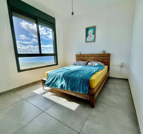 a bedroom with a bed and a large window at Apartment about Lake in Netanya