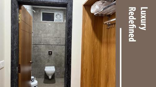 a bathroom with a toilet and a door with a window at Vishnu Grand Premium Rooms Rajahmundry in Rājahmundry