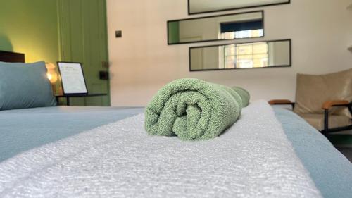 ein grünes Handtuch auf einem Bett in der Unterkunft Westminster Apartment in London