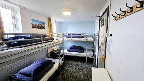 a room with three bunk beds and a window at Wooler Youth Hostel and Shepherds Huts in Wooler