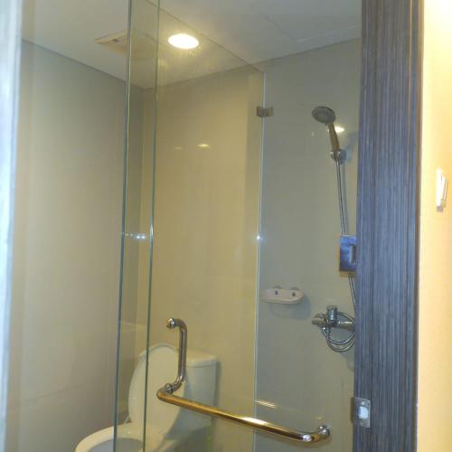a bathroom with a glass shower with a toilet at Apartemen Skylounge Balikpapan 2BR in Sepinggang-besar