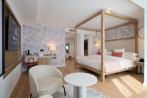 a bedroom with a canopy bed and a table and chairs at Óbal Urban Hotel in Marbella