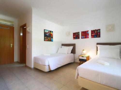 two beds in a room with white walls at Quinta do Lamy - Privat Pool & BBQ & Garden & Privacy & Beach & Benagil in Lagoa
