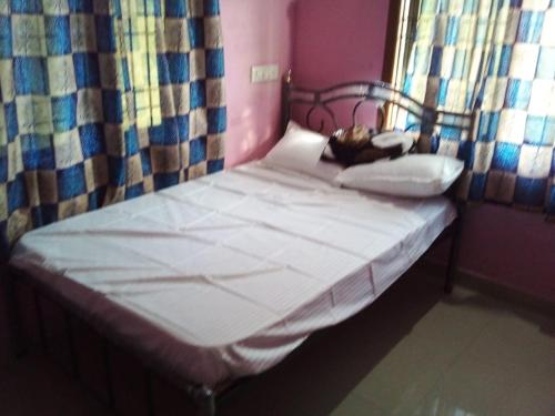 - un petit lit dans une chambre avec fenêtre dans l'établissement Honnavar homestays, à Honāvar