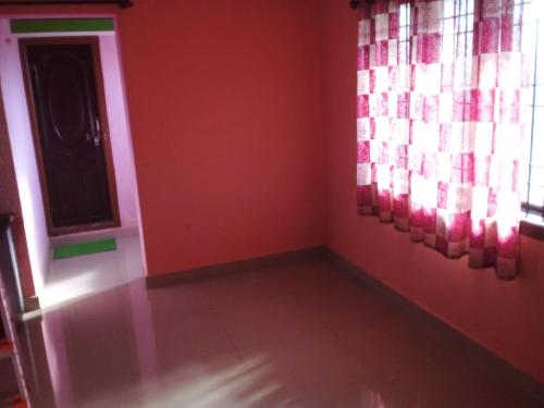Cette chambre est dotée de murs rouges et d'une fenêtre. dans l'établissement Honnavar homestays, à Honāvar