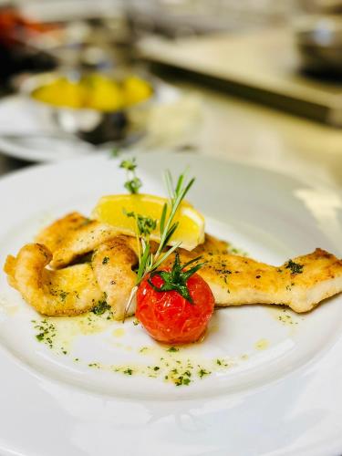 a plate of food with shrimp and a tomato on it at Gasthof Ziegler Hotel & Restaurant in Lindau