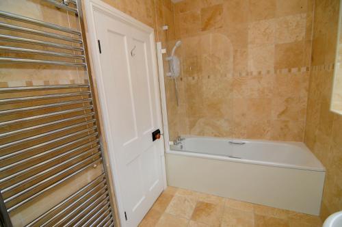 スラングランノグにあるGerlan Llangrannogのバスルーム(白いバスタブ、シャワー付)