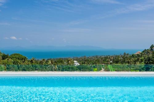 a swimming pool with the ocean in the background at Villa Murano Samui in Amphoe Koh Samui