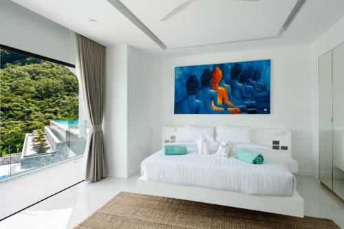 a white bedroom with a large bed and a large window at Villa Murano Samui in Amphoe Koh Samui