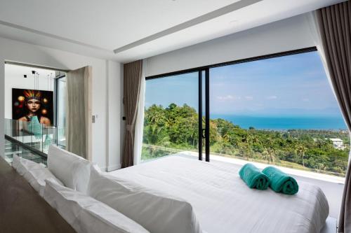 um quarto com uma cama branca e uma grande janela em Villa Murano Samui em Nathon Bay