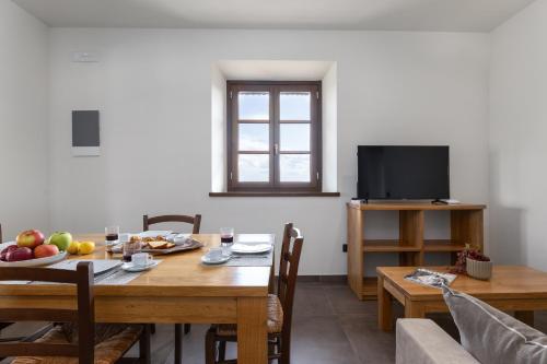 a dining room with a table and a television at Tuscany Living - Terra Antica in Montepulciano