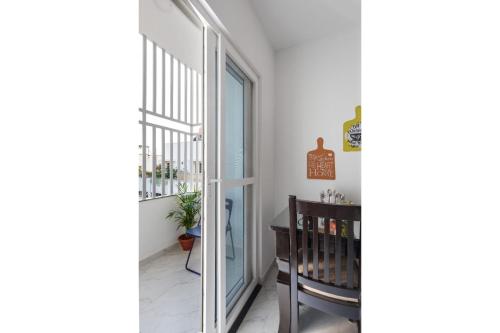 a hallway with a sliding glass door and a chair at Olive Serviced Apartments BTM Layout in Bengaluru