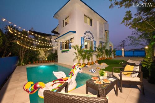 a backyard with a pool and a house with a horse swimming at EKOSTAY - Alpha Villa in Igatpuri