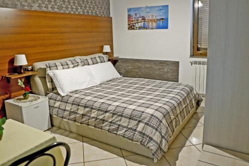 - une chambre avec un lit et une couverture en damier dans l'établissement Villa Nancy Affittacamere, à Cimitile