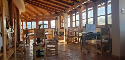 a room with a desk and chairs and windows at Lunandina Huaraz in Huaraz