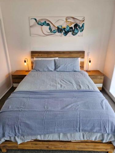 a bedroom with a bed with a blue comforter at Salisbury Apartments 8 in Christchurch