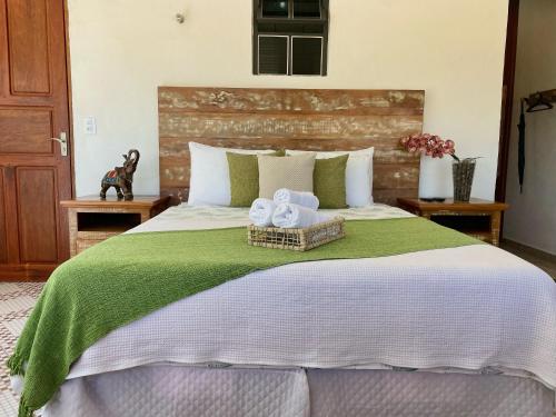 a bedroom with a bed with two towels on it at Pouso das Flores -350m Maria Fumaça in Tiradentes