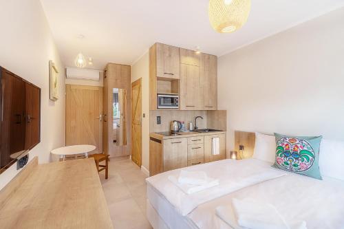 a small room with a bed and a kitchen at Tramonto Apartments Zator Przeciszów in Zator