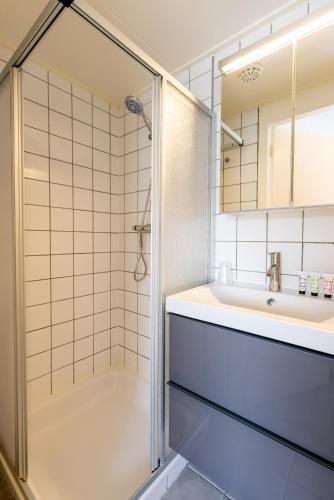 a bathroom with a shower and a sink at De Berkenhof in Nes