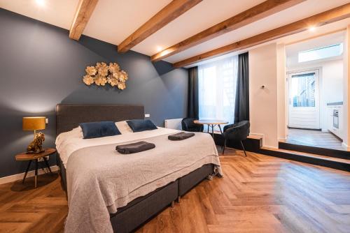a bedroom with a large bed and a table at Familie Hotel & Apartments Alkmaar in Alkmaar