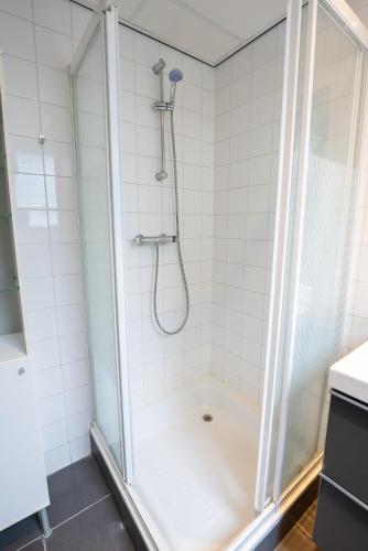 a shower with a glass enclosure in a bathroom at De Berkenhof in Nes