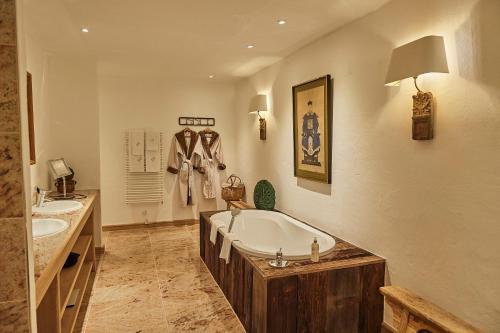 ein großes Badezimmer mit zwei Waschbecken und einer Badewanne in der Unterkunft BLEICHE RESORT & SPA in Burg