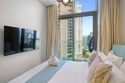 Schlafzimmer mit einem großen Fenster und einem großen weißen Bett in der Unterkunft High-floor 2br In Aykon City Spacious, Good View in Dubai