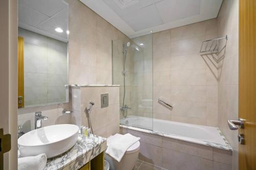 ein Badezimmer mit einem Waschbecken, einer Badewanne und einem WC in der Unterkunft High-floor 2br In Aykon City Spacious, Good View in Dubai
